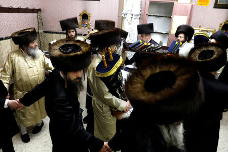 Ultra-Orthodox Jewish men dance with Torah scrolls during the celebrations of Simchat Torah in a synagogue at the Mea Shearim neighbourhood of Jerusalem October 1 , 2018. REUTERS/Ronen Zvulun