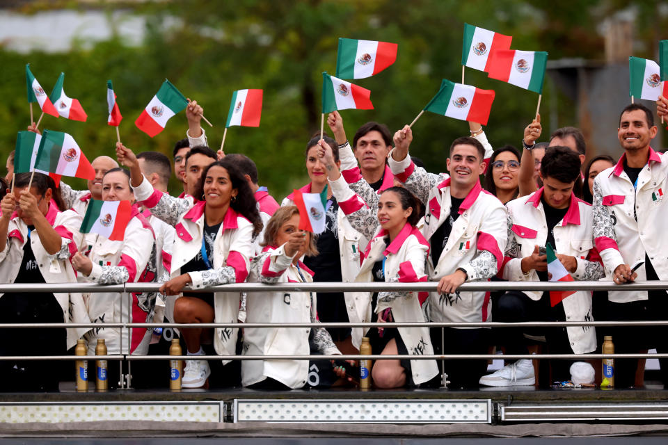 PARIS, FRANCE - JULY 26: Athletes of Team Mexico wave handheld flags as they cruise during the athletes' parade on the River Seine during the opening ceremony of the Olympic Games Paris 2024 on July 26, 2024 in Paris, France. (Photo by Michael Reaves / POOL / AFP) (Photo by MICHAEL REAVES/POOL/AFP via Getty Images)