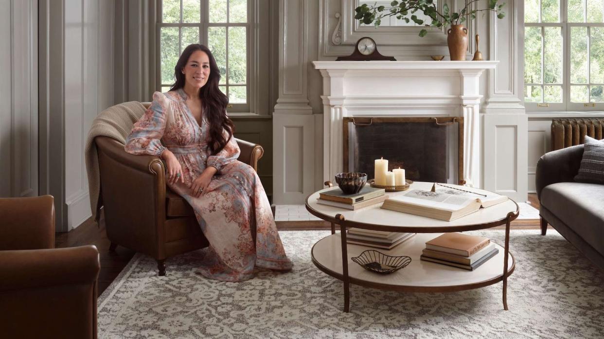  Joanna Gaines in a living room amongst Magnolia Home by Joanna Gaines x Loloi collection it's neutral styled. 