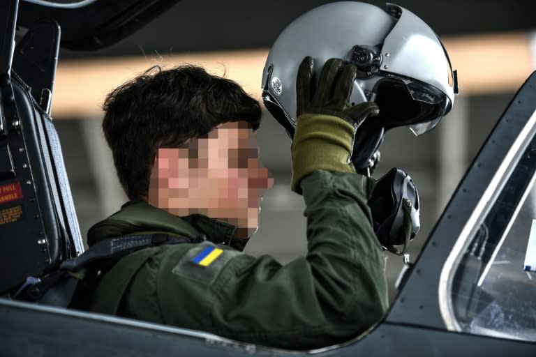 A Ukrainian trainee puts on his helmet ahead of a flight with a French instructor onboard an Alpha Jet trainer aircraft at an air base in southwest France (Christophe ARCHAMBAULT)