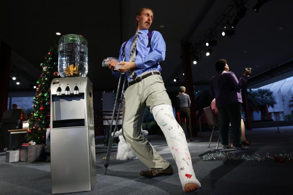 A partier puts a fish into the water dispenser inside Alex Prager's LACMA installation (Dania Maxwell / Los Angeles Times)