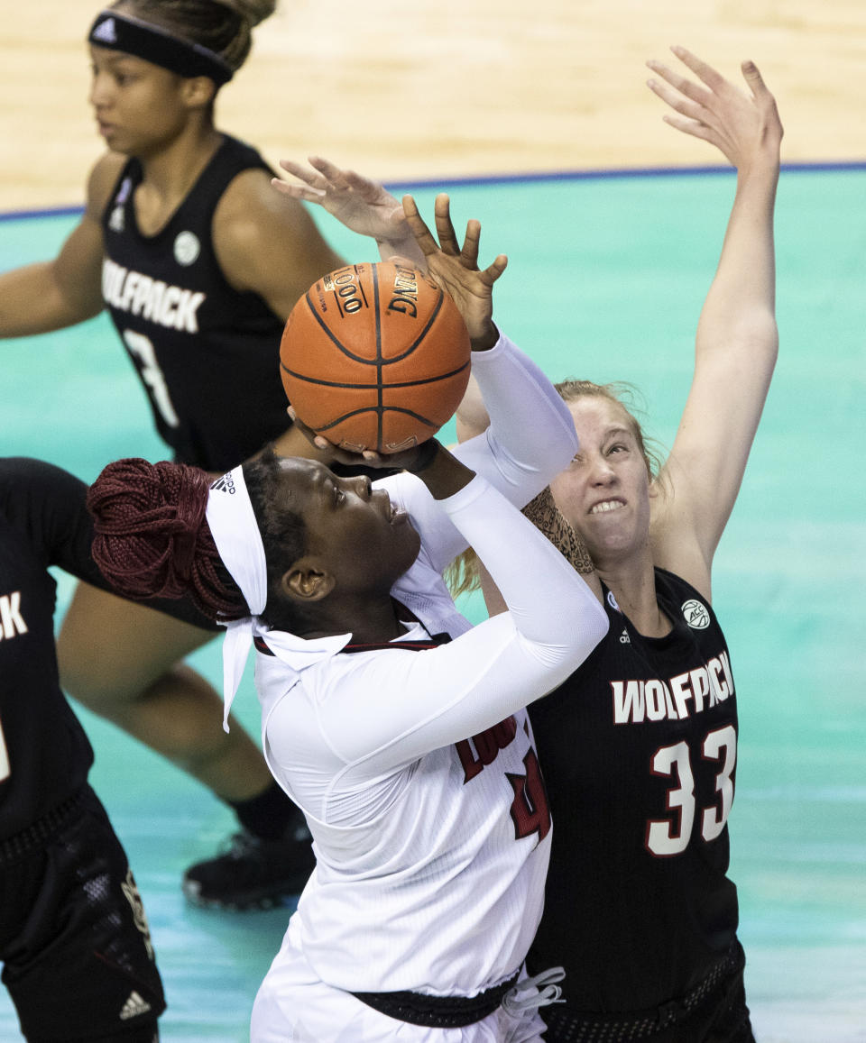 Louisville's Olivia Cochran (44) attempts a shot over North Carolina State's Elissa Cunane (33) during the championship of Atlantic Coast Conference NCAA women's college basketball game in Greensboro, N.C., Sunday, March 7, 2021. (AP Photo/Ben McKeown)