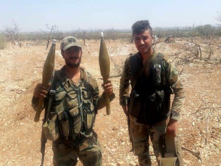 A Syrian army soldier holds weapons in Idlib countryside