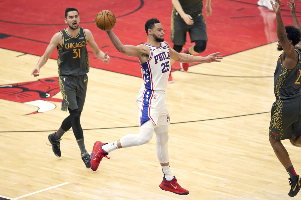 Philadelphia 76ers' Ben Simmons (25) saves the ball from going out of bounds with a long pass as Chicago Bulls' Tomas Satoransky (31) and Thaddeus Young watch during the second half of an NBA basketball game Monday, May 3, 2021, in Chicago. (AP Photo/Charles Rex Arbogast)