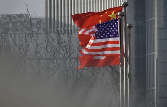 Chinese and U.S. national flags flutter at the entrance of a company office building in Beijing.