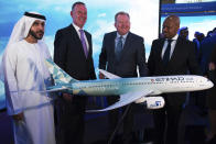 Etihad COO Mohammad al-Bulooki, left, Etihad CEO Tony Douglas, second left, Boeing Commercial Airplanes president and CEO Stanley A. Deal, third left, and Boeing Global Services President and CEO Ted Colbert, right, pose in front of a Boeing 787 Dreamliner model at the Dubai Airshow in Dubai, United Arab Emirates, Monday, Nov. 18, 2019. Abu Dhabi's flagship carrier Etihad said Monday it had partnered with Boeing Co. to launch what they say will be one of the world's most fuel-efficient long haul airplanes as the company seeks to save costs on fuel and position itself as a more environmentally-conscious choice for travelers. (AP Photo/Jon Gambrell)