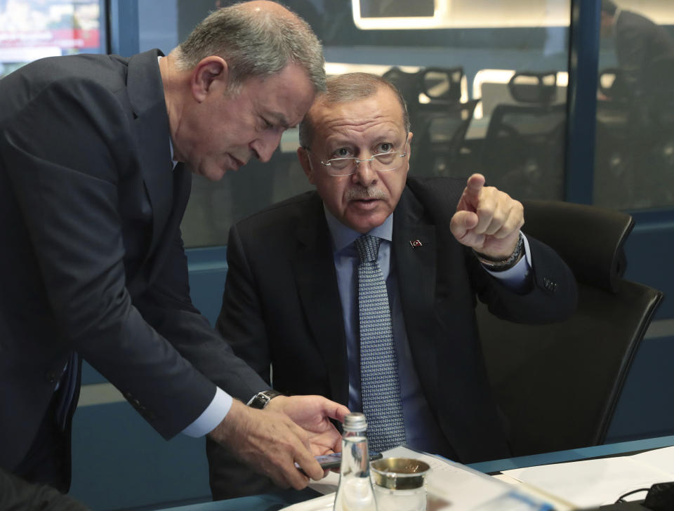 Turkey's President Recep Tayyip Erdogan, right, speaks with Defense Minister Hulusi Akar in an operation room at presidential palace, in Ankara, Turkey, Wednesday, Oct. 9, 2019. Turkey launched a military operation Wednesday against Kurdish fighters in northeastern Syria after U.S. forces pulled back from the area, with a series of airstrikes hitting a town on Syria's northern border. (Turkish Presidency Press Service via AP, Pool)