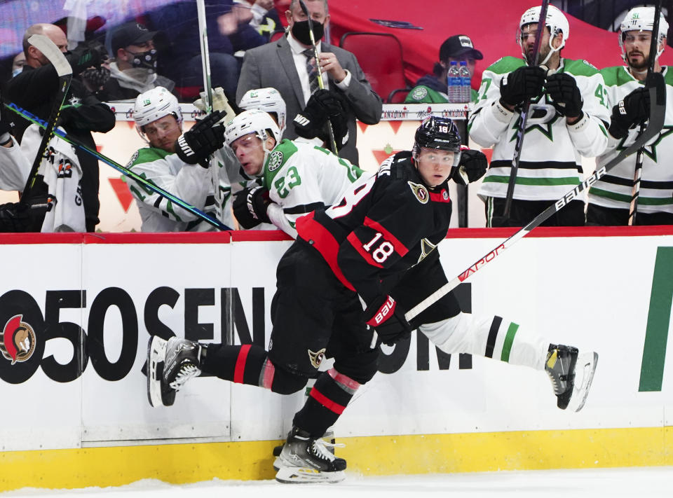 Ottawa Senators' Alex Formenton (10) hits Dallas Stars' Esa Lindell (23) into the boards during the first period of an NHL hockey game, Sunday, Oct. 17, 2021, in Ottawa, Ontario. (Sean Kilpatrick/The Canadian Press via AP)