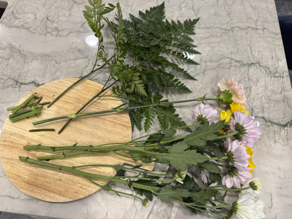 This May 2, 2024 image shows flowers with their stems trimmed on an angle. The practice maximizes the stem's surface area, allowing flowers to take up more water and preventing blockages that can result when stems lay flat against container bottoms. (AP Photo/Sallee Ann Harrison)