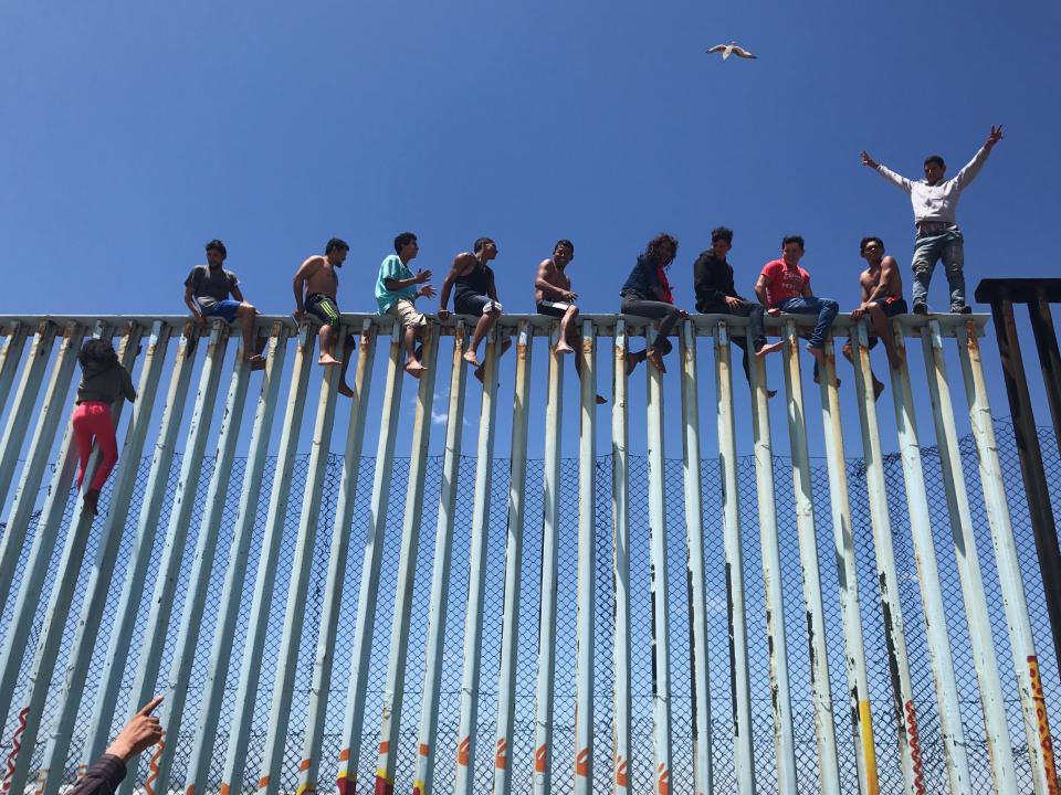 Third Place<br />"Refugee Caravan"<br />Members of the Refugee Caravan 2017 climb the border fence dividing Mexico and the U.S. to celebrate their arrival in Tijuana.<br />Tijuana, Baja California, Mexico<br />Shot on iPhone 6S<br />