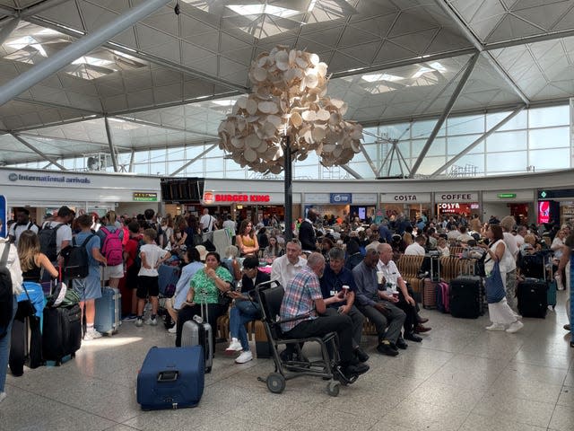 Passengers wait at London Stansted Airport in Essex, amid reports of widespread IT outages affecting airlines