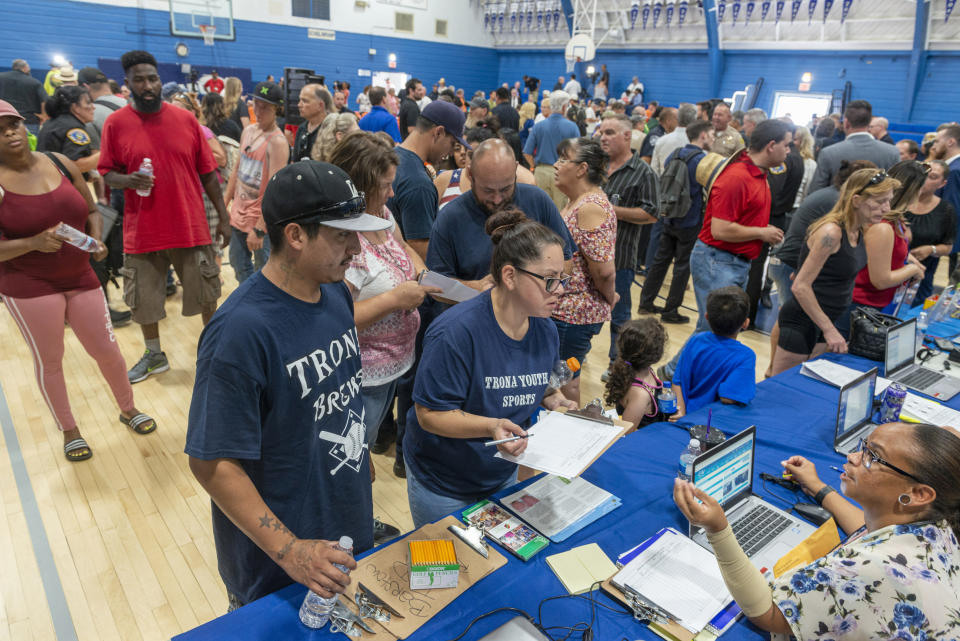 Trona residents line up at the San Bernardino County's Transitional Assistance program on Wednesday July 10, 2019, in Trona, Calif., as the high school gym was converted into a local assistance center for recovery after a pair of earthquakes struck the unincorporated community. KCBS-TV reports the most common concern expressed by residents is the lack of running water. (James Quigg/The Daily Press via AP)