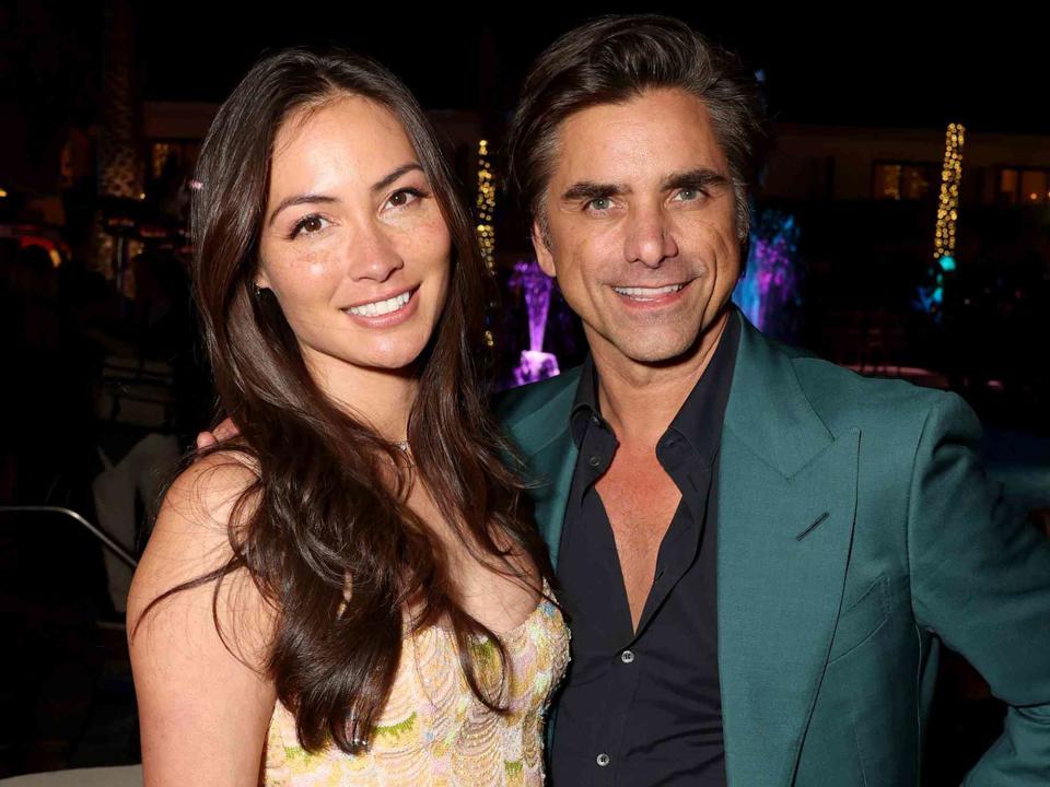 <p>Jesse Grant/Getty</p> Caitlin McHugh and John Stamos at the World Premiere of 