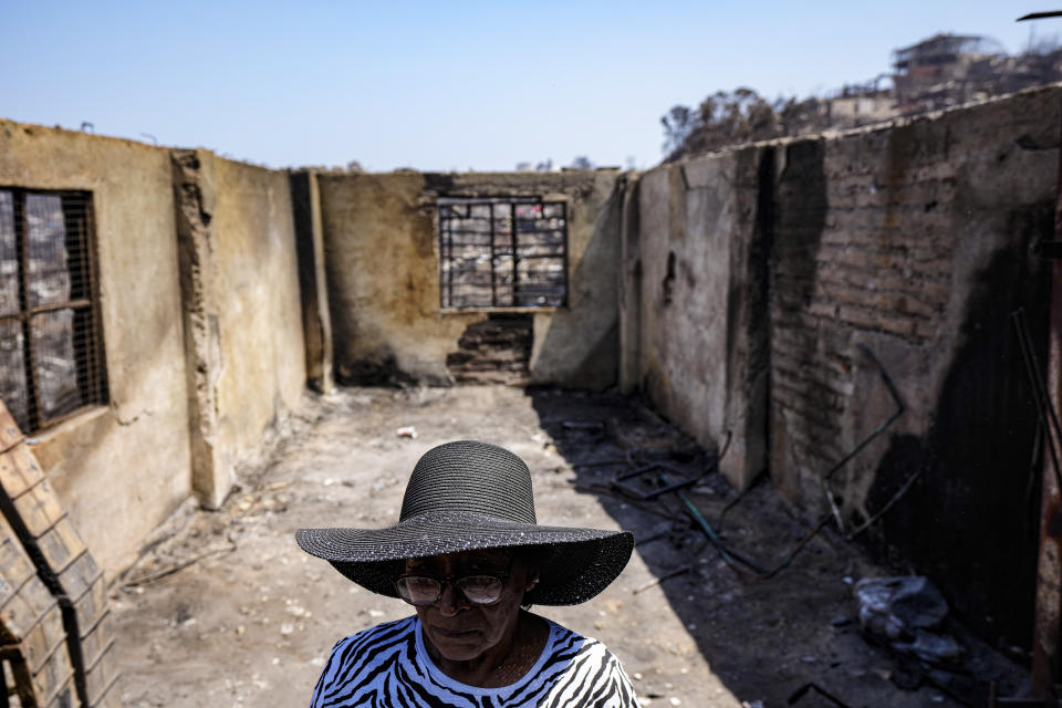 Aminta Guerra stands inside what is left of her charred home after a deadly forest fire affected the El Olivar neighborhood of Vina del Mar, Chile, Monday, Feb. 5, 2024. (AP Photo/Esteban Felix)