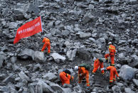 <p>Rescue workers search for survivors at the site of a landslide that occurred in Xinmo Village, Mao County, Sichuan province, China, June 24, 2017. The writing on the flag reads: “Chengdu Fire Departmant Rescue Team”. (Photo: Stringer/Reuters) </p>