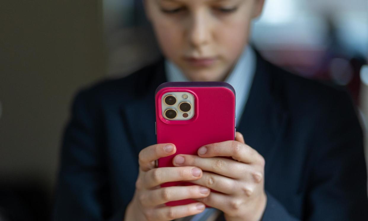 <span>A 12-year-old school boy looks at a iPhone screen.</span><span>Photograph: Matt Cardy/Getty Images</span>