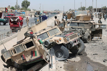 Afghan National Army (ANA) soldiers inspect damaged army vehicles after a suicide attack in Lashkar Gah, Helmand province, Afghanistan August 23, 2017. REUTERS/Stringer