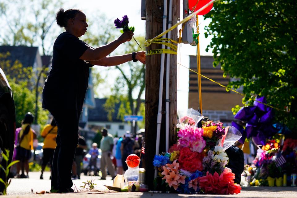 A woman tends to a makeshift memorial outside the scene of a shooting at a supermarket the day before, in Buffalo, N.Y., Sunday, May 15. [AP Photo/Matt Rourke)