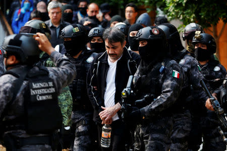 Accused drug kingpin Damaso Lopez (C), nicknamed “The Graduate”, is escorted by police officers in Mexico City, Mexico May 2, 2017. REUTERS/Carlos Jasso