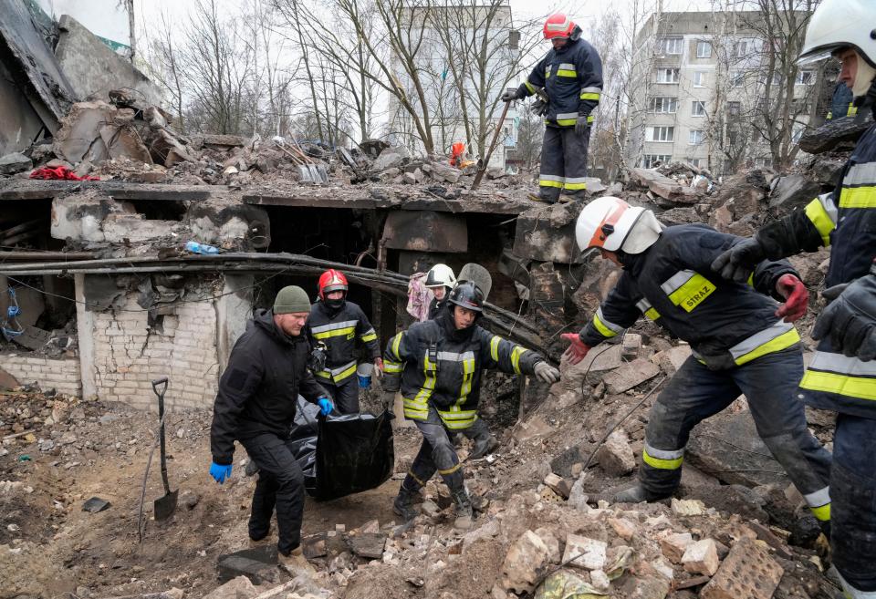 Emergency workers remove the body of a resident of a multi-storey building destroyed in a Russian air raid at the beginning of the Russia-Ukraine war in Borodyanka, close to Kyiv, Ukraine, Saturday, April 9, 2022. AP Photo/Efrem Lukatsky