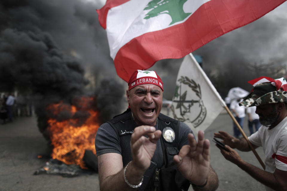 Lebanese retired soldiers protest in front of the government building during a cabinet meeting to discuss an austerity budget, in Beirut, Lebanon, Friday, May 10, 2019. Dozens of Lebanese military and security veterans burned tires and shouted angrily outside government offices on Friday, their second protest in less than two weeks amid fears a proposed austerity budget may affect their pensions and benefits. (AP Photo/Hassan Ammar)