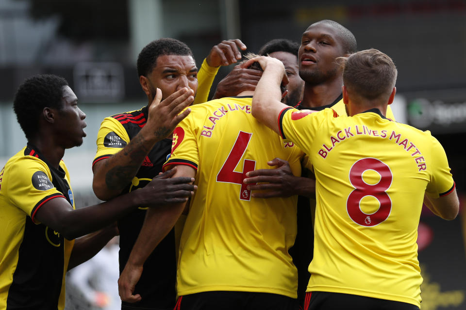 Watford's Craig Dawson (4), celebrates with teammates after scoring his side's opening goal during the English Premier League soccer match between Watford and Leicester City at the Vicarage Road Stadium in Watford, England, Saturday, June 20, 2020. (AP Photo/Alastair Grant, POOL)