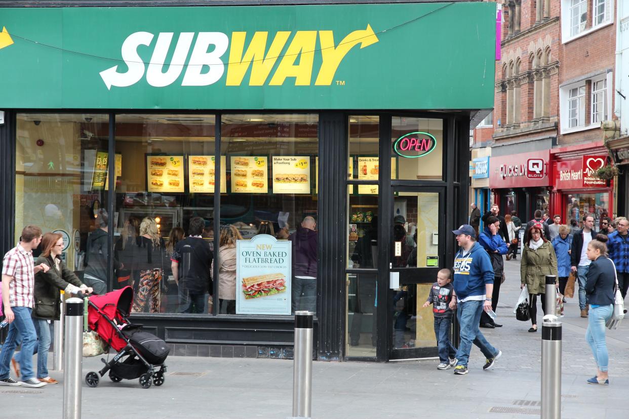 People pass by Subway sandwich shop in Liverpool. Subway has 44,280 fast food restaurants in 110 countries.