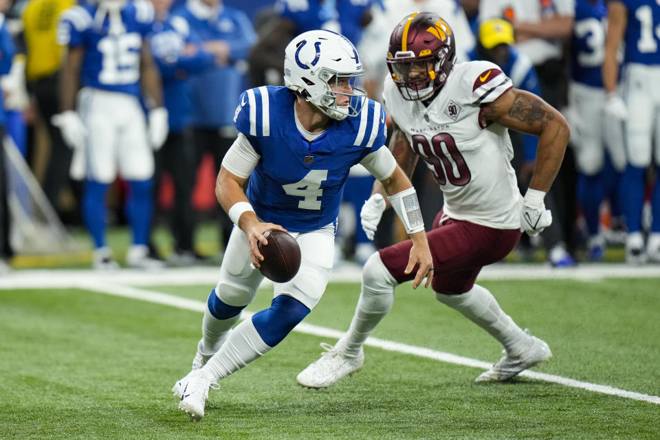 Indianapolis Colts quarterback Sam Ehlinger (4) evades Washington Commanders defensive end Montez Sweat (90) as he scrambles in the first half of an NFL football game in Indianapolis, Sunday, Oct. 30, 2022. (AP Photo/AJ Mast)