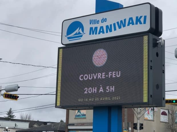 A sign advertising the curfew in Maniwaki, Que., in April 2021.