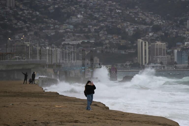 Una joven toma fotos con su teléfono inteligente de la alta mar en Viña del Mar, Chile, el 12 de junio de 2024