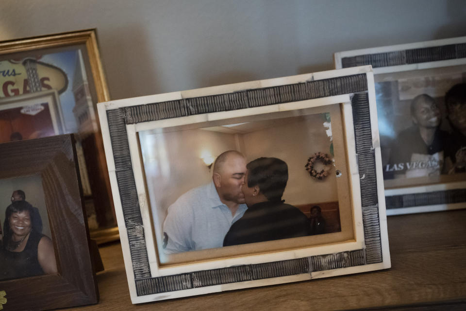 A framed photo of Melanese Marr-Thomas kissing her late husband, Charles Thomas, during their wedding ceremony, sits with other family photos, at their home in District Heights, Md., on Wednesday, Sept. 21, 2022. The couple blended their families, and he never shied away from talking about his earlier struggles in life. He acknowledged his mistakes and instead used it as a powerful way to teach his children to avoid the pitfalls he fell prey to. (AP Photo/Wong Maye-E)