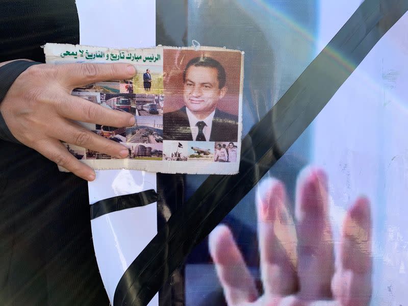 Supporters of former Egyptian President Hosni Mubarak wait before the funeral in Cairo