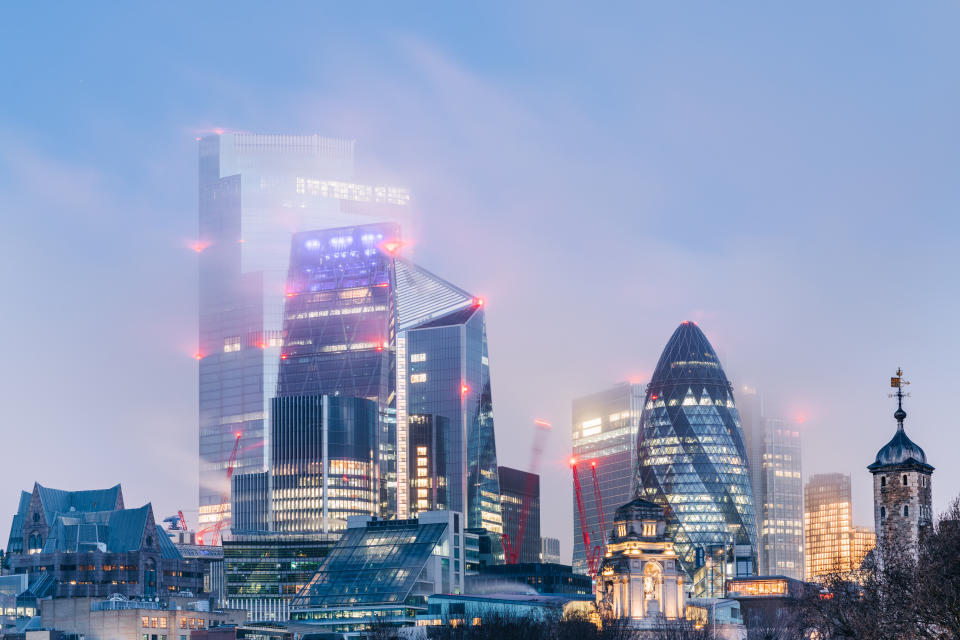 A surface level view of London city buildings shrouded in mist