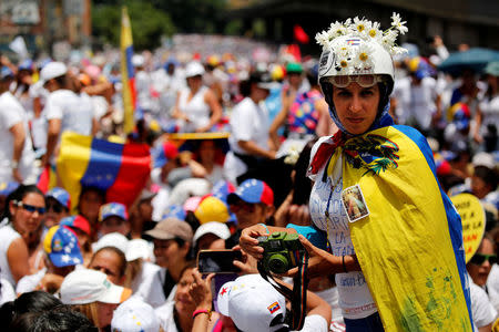 A demonstrator holds a camera as she attends a women's march to protest against President Nicolas Maduro's government in Caracas, Venezuela May 6, 2017. REUTERS/Carlos Garcia Rawlins