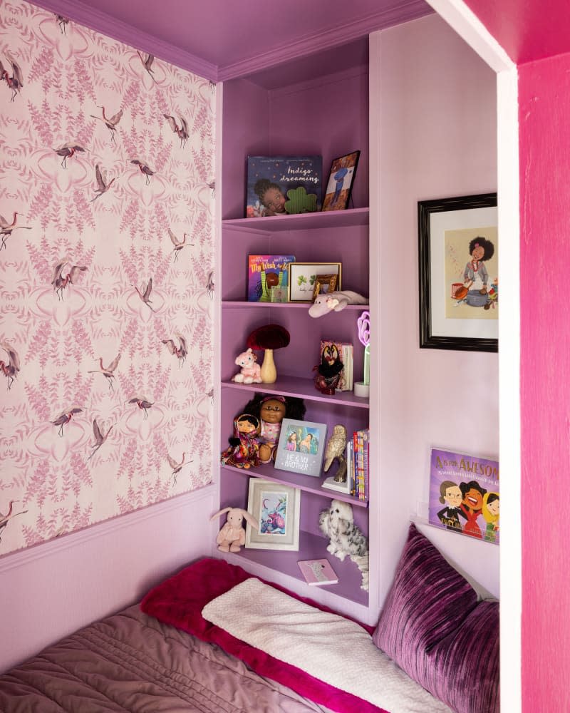 pink and purple bed nook with shelves and art in kids room after makeover