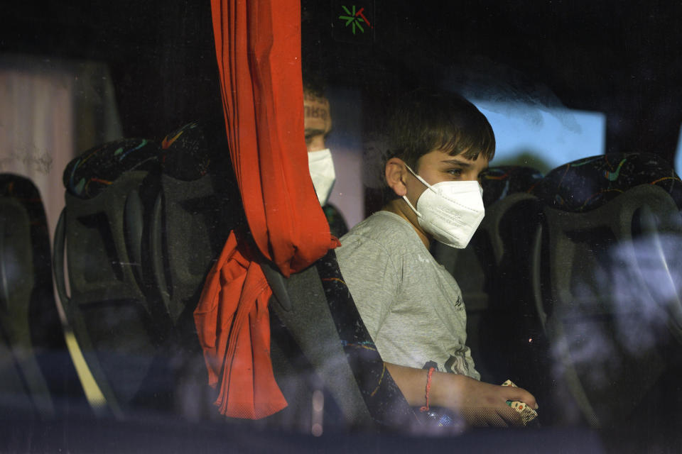 Migrants sit in a coach as they arrive at the holiday camping center in Hyeres, France, Friday, Nov. 11, 2022. The migrants had been onboard the Norwegian-flagged vessel the Ocean Viking, operated by the NGO SOS Méditerranée, and had been at sea for nearly three weeks carrying around 230 migrants. Italy had refused to allow the migrants to disembark on Italian territory. (AP Photo/Daniel Cole)