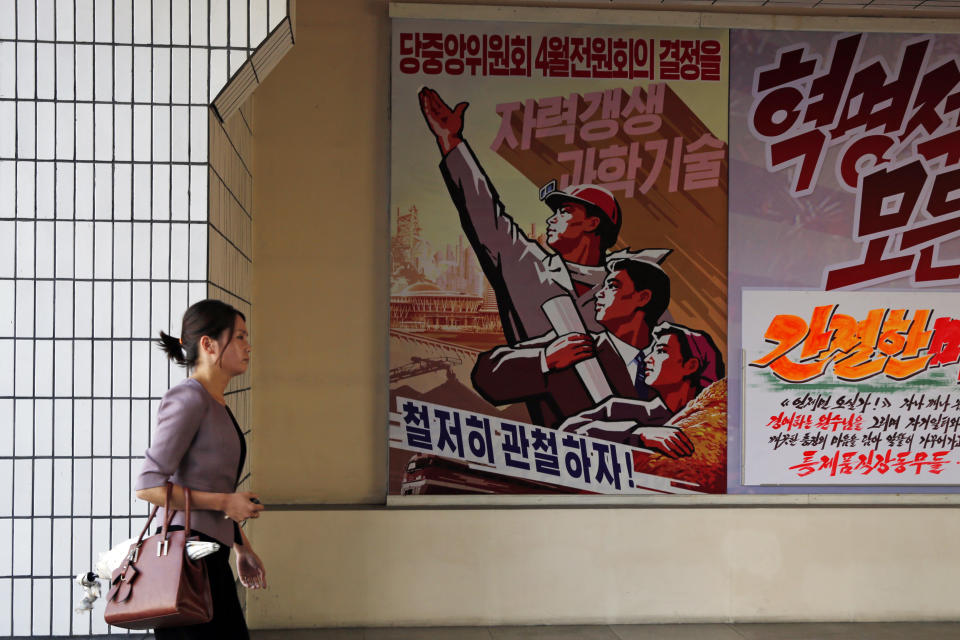 A North Korean woman walks past slogans at the Pyongyang Cosmetics Factory in Pyongyang, North Korea, Saturday, Sept. 8, 2018. The Pyongyang Cosmetics Factory, which was recently renovated, is one of the North’s main producers of cosmetic items. A poster at left reads “Let’s thoroughly implement the decisions of the April meeting of the Central Committee of the Workers’ Party of Korea.” (AP Photo/Kin Cheung)