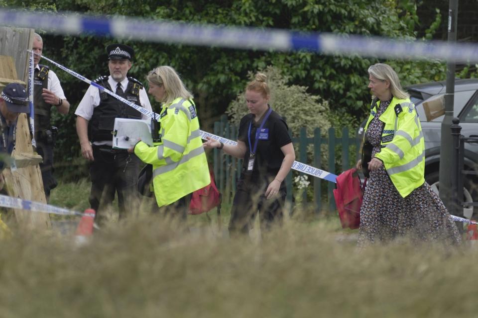 Police officers investigate after a car crashed into a primary school building in Wimbledon, London, Thursday, July 6, 2023. London police say a girl died when an SUV crashed into an elementary school on a very narrow road in the Wimbledon district of southwest London. The Metropolitan Police said Thursday that there have been further injuries but did not provide details of how many. (AP Photo/Kin Cheung)