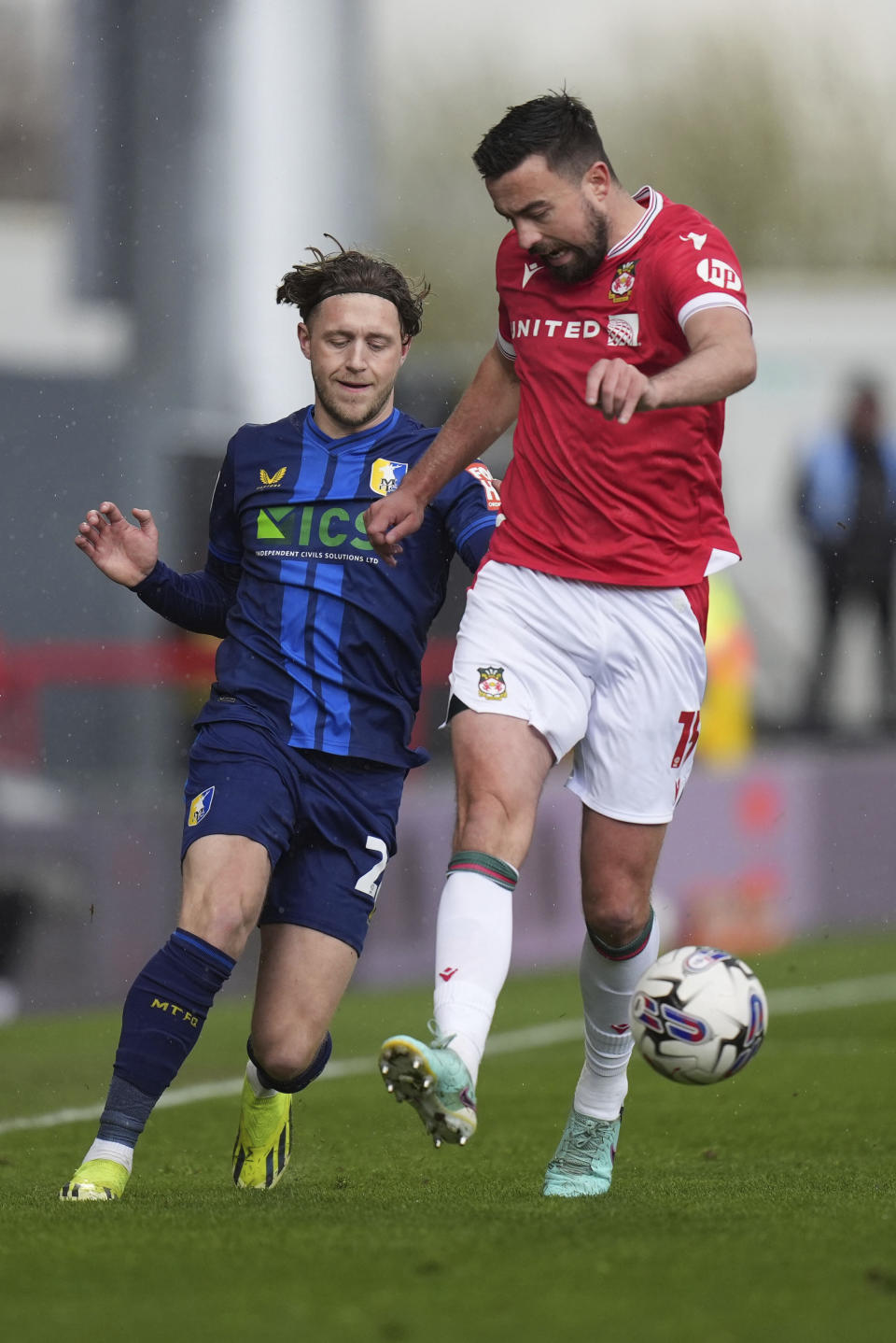 Wrexham's Eoghan O'Connell, right, and Mansfield Town's Will Swan challenge for the ball during the English League Two soccer match between Wrexham and Mansfield Town at the SToK Cae Ras in Wrexham, Wales, Friday, March 29, 2024. (Jacob King/PA via AP)