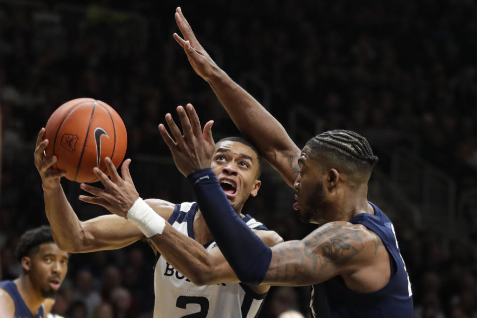 Butler guard Aaron Thompson (2) shoots under pressure from Xavier forward Tyrique Jones (4) in the first half of an NCAA college basketball game in Indianapolis, Wednesday, Feb. 12, 2020. (AP Photo/Michael Conroy)