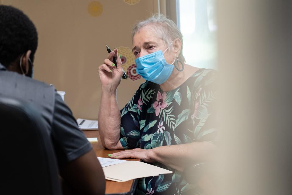 Macomb County Rotating Emergency Shelter Team (MCREST) case manager Jane Mahoney asks questions to Taijh Robinson of Warren while seeing how their program can help him out after becoming homeless following a fire to his mother's home on July 26, 2021 at the MCREST building in Roseville.