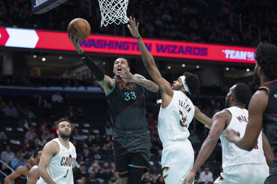 Washington Wizards forward Kyle Kuzma (33) drives against Cleveland Cavaliers defender, center Jarrett Allen (31) during the first half of an NBA basketball game, Sunday, Feb. 25, 2024, in Washington. (AP Photo/Manuel Balce Ceneta)