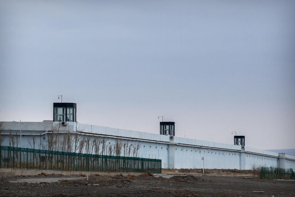 FILE - People stand in a guard tower on the perimeter wall of the Urumqi No. 3 Detention Center in Dabancheng in western China's Xinjiang Uyghur Autonomous Region on April 23, 2021. State officials took AP journalists on a tour of a "training center" turned detention site in Dabancheng sprawling over 220 acres and estimated to hold at least 10,000 prisoners - making it by far the largest detention center in China and among the largest on the planet. (AP Photo/Mark Schiefelbein, File)