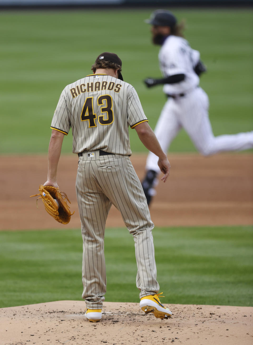 San Diego Padres starting pitcher Garrett Richards, front, reacts after giving up a two-run home run to Colorado Rockies' Charlie Blackmon, back, in the first inning of a baseball game Friday, July 31, 2020, in Denver. (AP Photo/David Zalubowski)