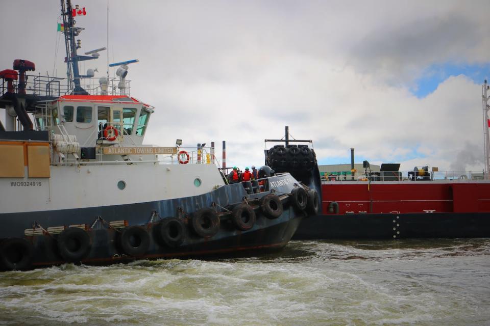 The Atlantic Fir helps to undock a barge headed to the United States with a cargo of asphalt. 