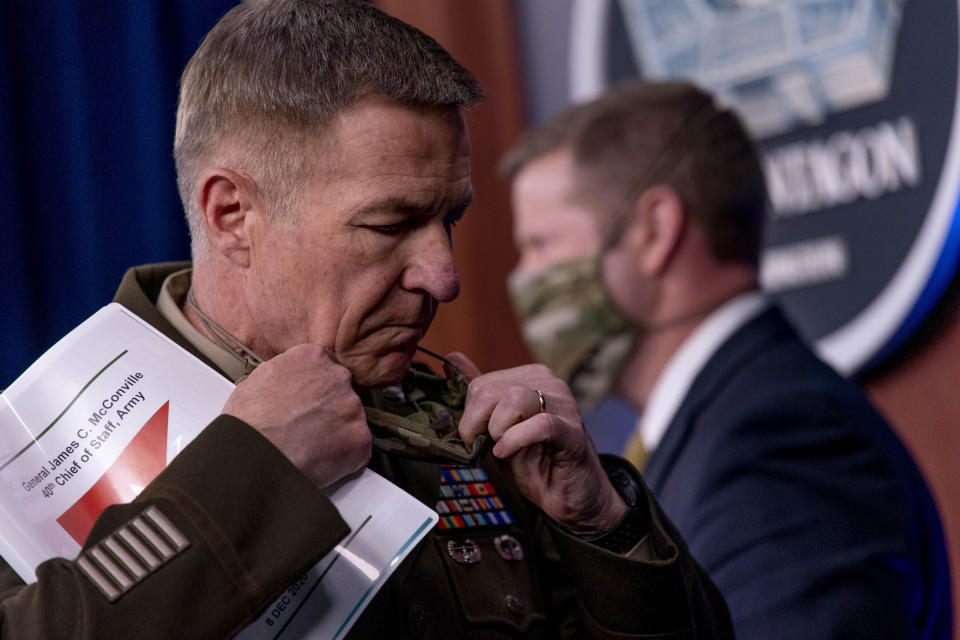 Gen. James McConville, Chief of Staff of the Army, left, steps away from the podium as Secretary of the Army Ryan McCarthy, right, prepares to speak at a briefing on an investigation into Fort Hood, Texas at the Pentagon, Tuesday, Dec. 8, 2020, in Washington. The Army says it has fired or suspended 14 officers and enlisted soldiers at Fort Hood, Texas, and ordered policy changes to address chronic leadership failures at the base that contributed to a widespread pattern of violence including murder, sexual assaults and harassment. (AP Photo/Andrew Harnik)