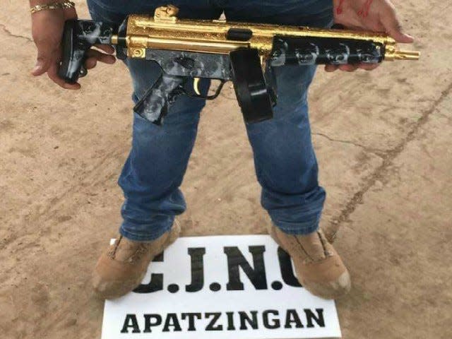 Cartel member shows off gold-plated gun.