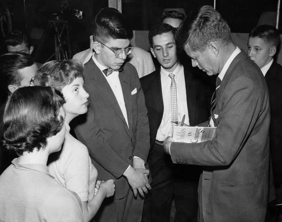 <p>Sen. John F. Kennedy signs a copy of his book “Profiles in Courage” for a young fan, circa 1956-1957. (Photo: John F. Kennedy Presidential Library and Museum) </p>