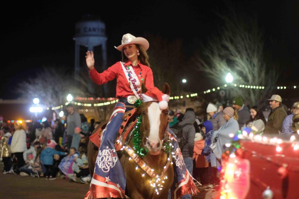 A rider waves to the crowd Saturday night during the Parade of Lights in Canyon, Texas.