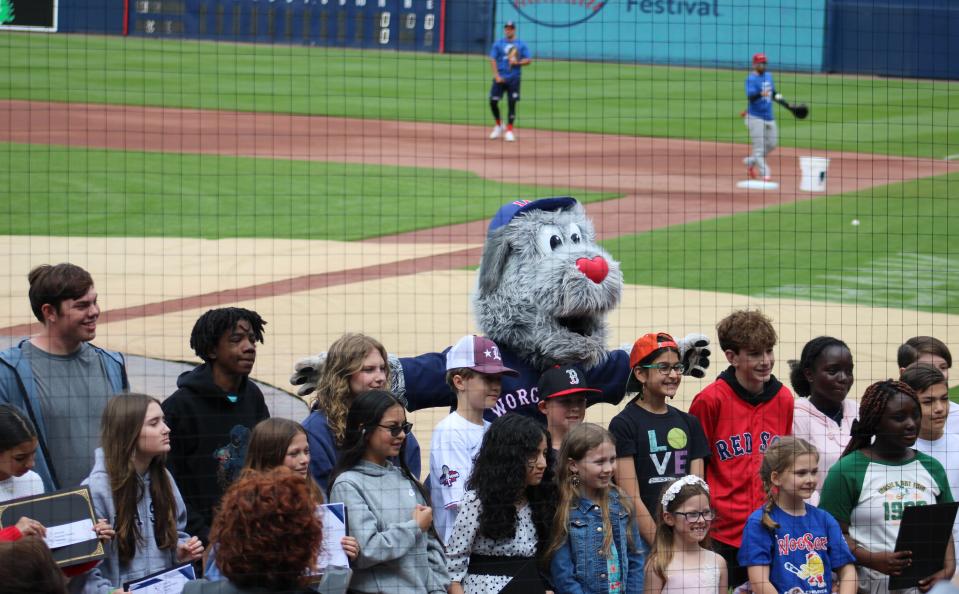 Student poem honorees gather on the field at Polar Park with mascot, Woofster, before the Woo Sox's game on May 4, 2024.